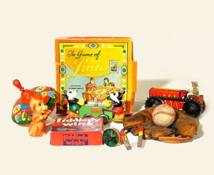 A collection of antique children's toys including a top, baseball and glove, red toy tractor and games.