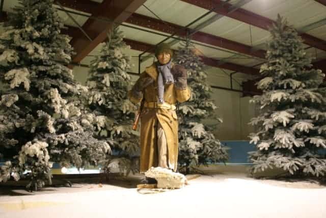Mannequin representing Indigenous trapper stands on a snowy hill