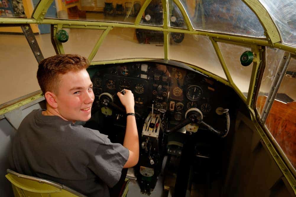 Young man sits in the cockpit of an Airspeed Oxford Mark I and looks out