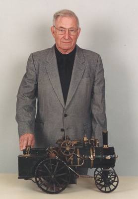 Fred Dalby stands behind his model steam engine