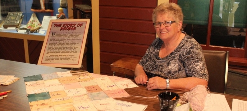 Volunteer seated at friendship quilt activity at WDM Yorkton