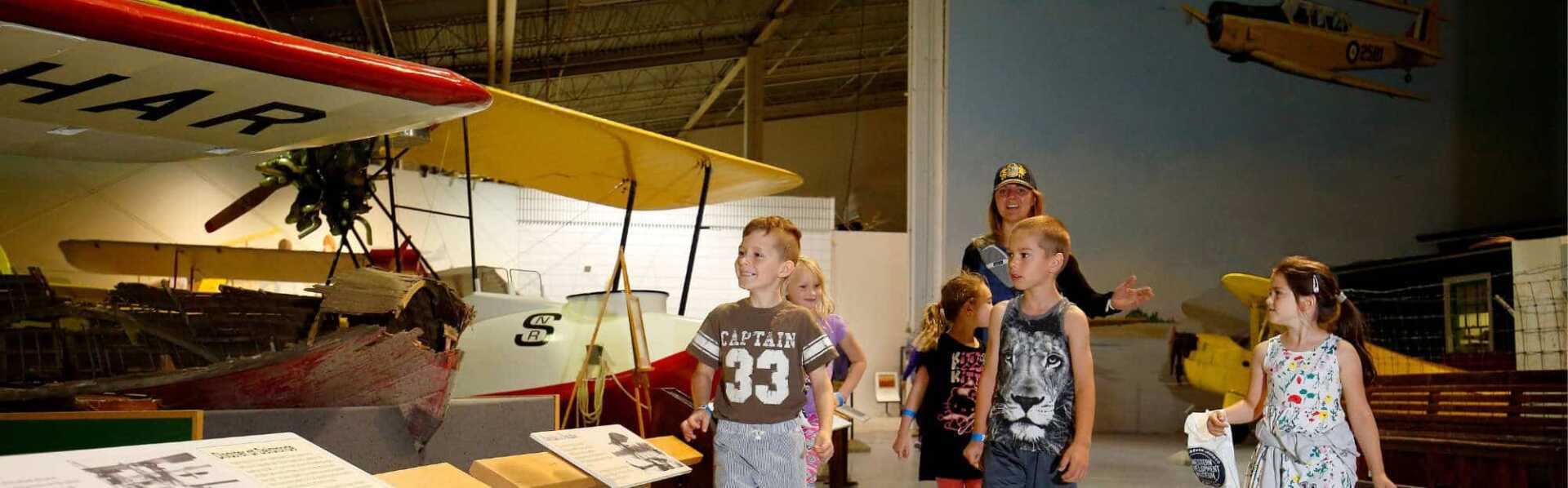 A group of children visiting the aviation gallery at the WDM Moose Jaw.