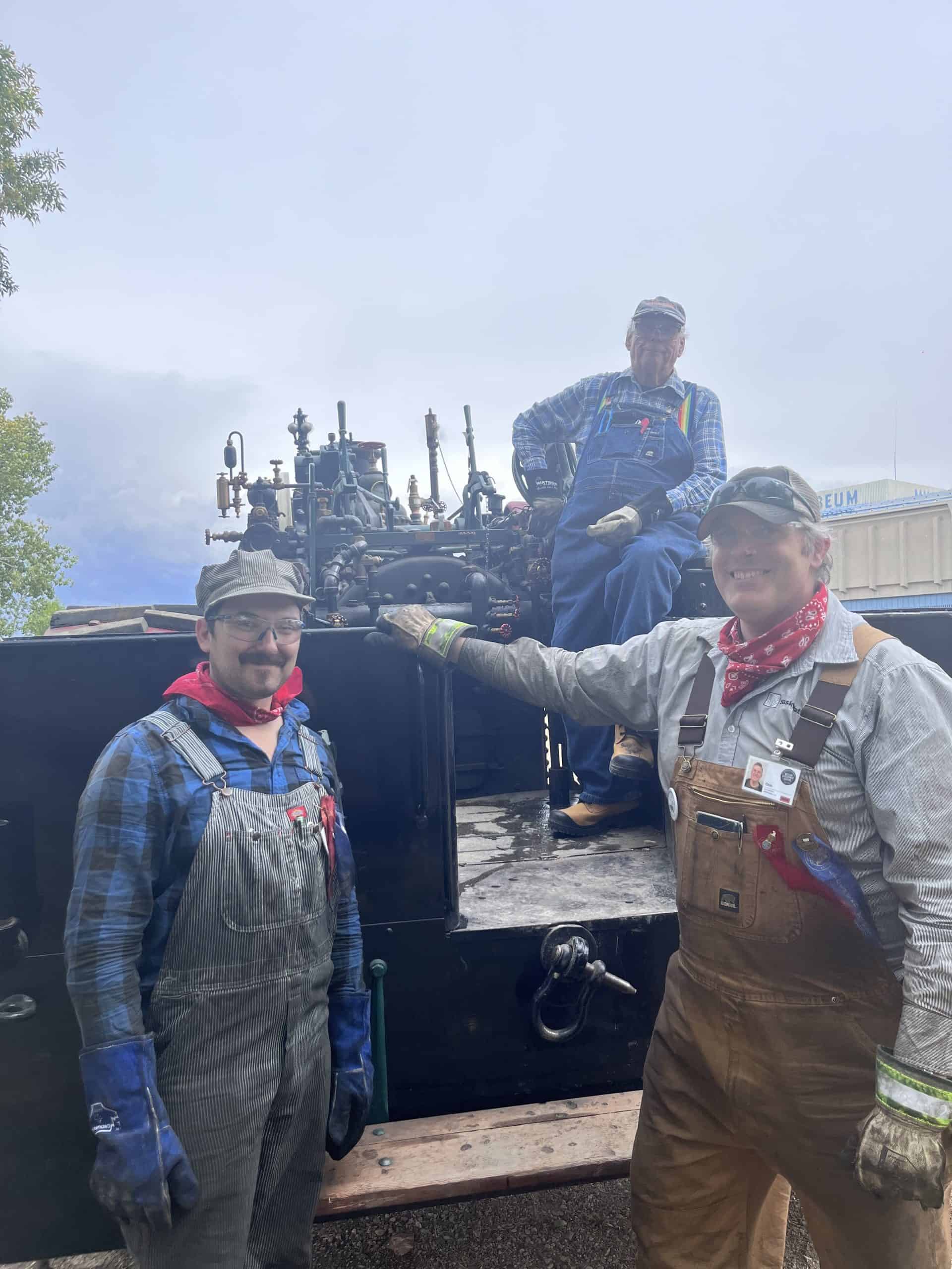 Three men at the back of a 75 Case steam traction engine