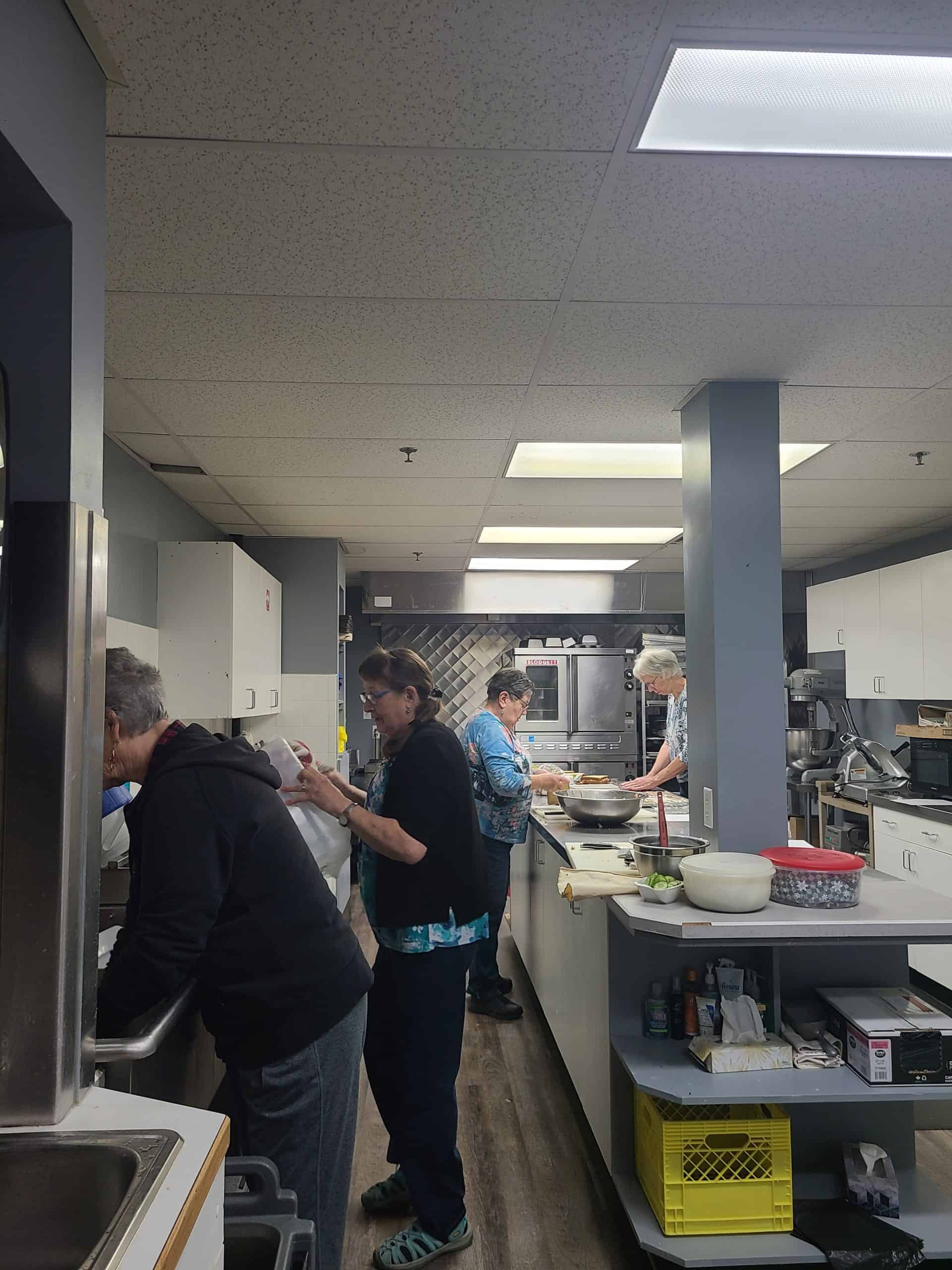 People work in industrial looking kitchen