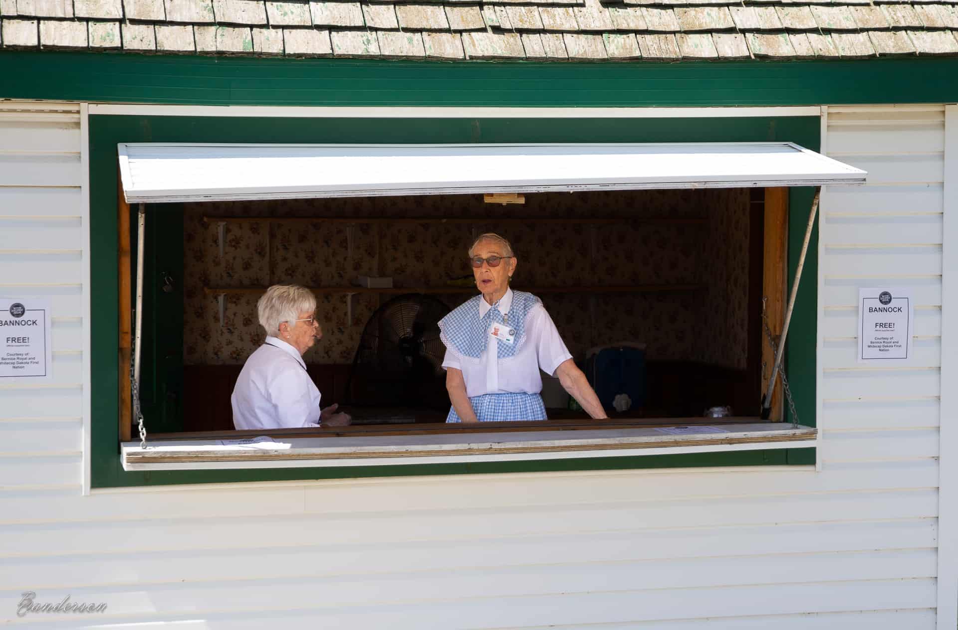 Two women visit inside a concession stand.