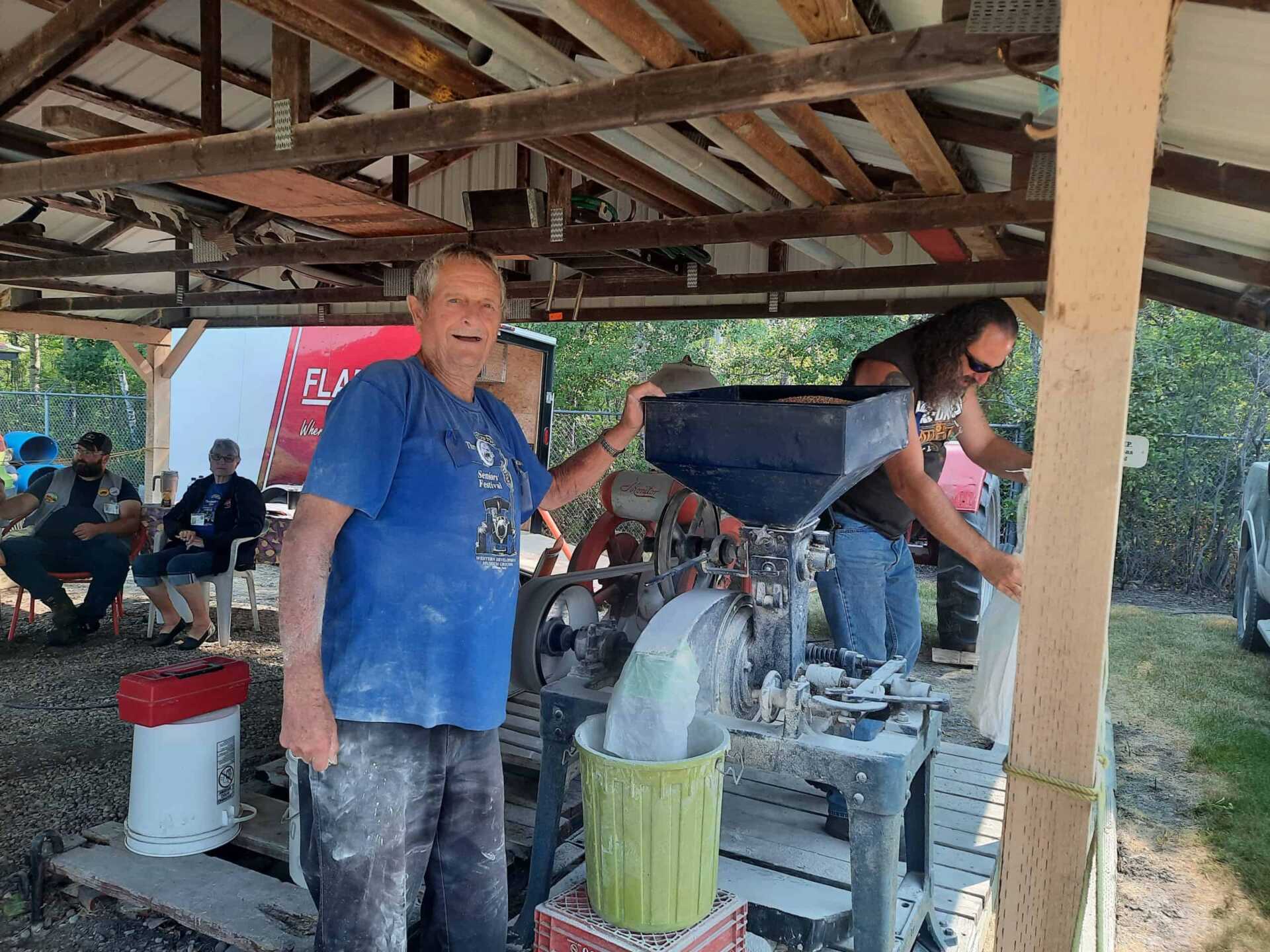 Volunteers with a grain grinder