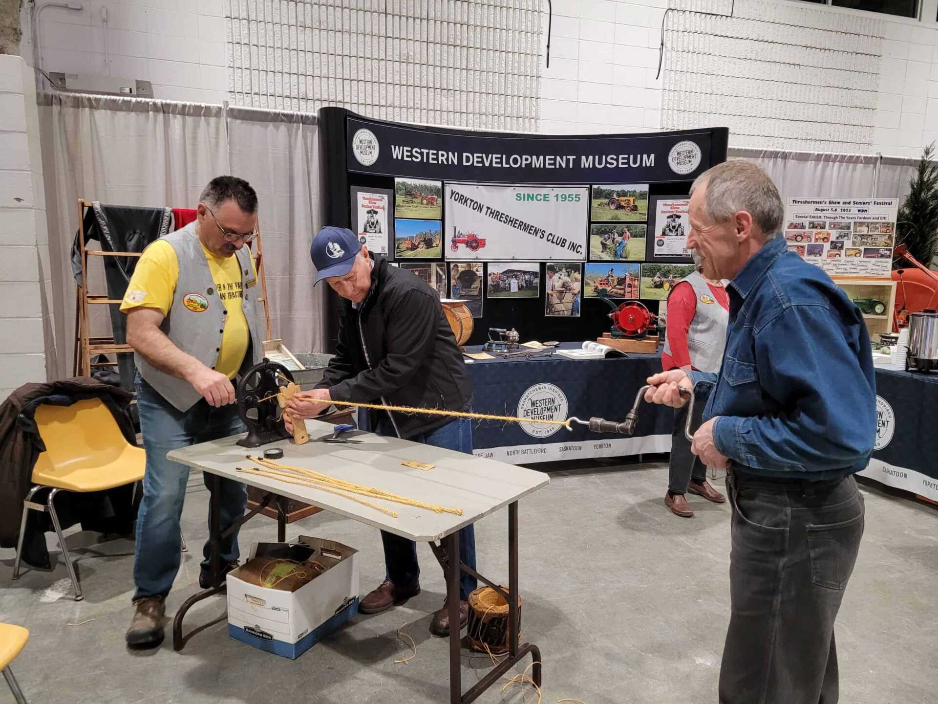 Three men making rope