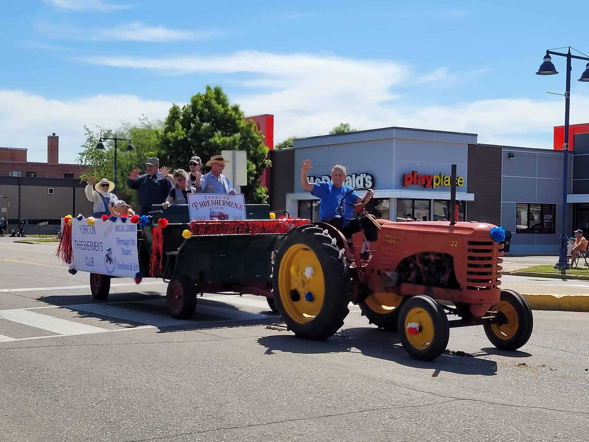 Tractor pulling wagon with signs promoting the Yorkton Threshermen's Club.