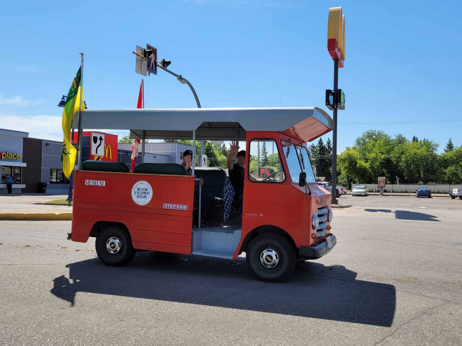 Orange people mover along a parade route