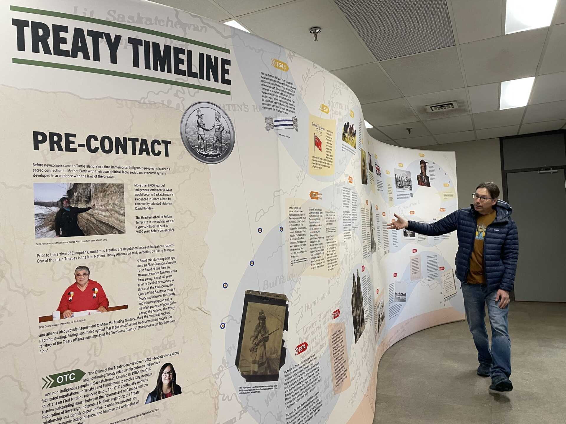 A man looks at a large wall display with facts about treaties in Saskatchewan.